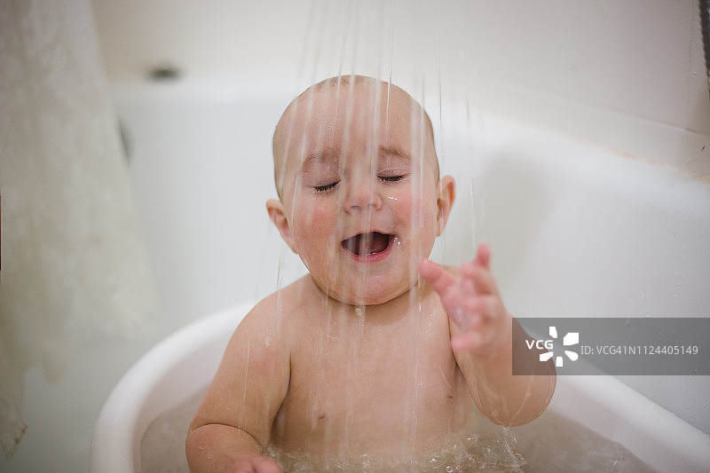 在浴缸里玩水的男婴图片素材