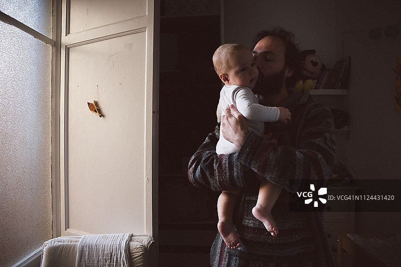 早上，爸爸亲吻男婴图片素材