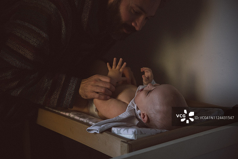 爸爸给男婴换尿布图片素材