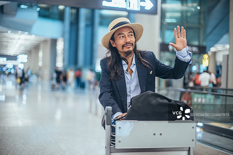 在机场航站楼推购物车的男子图片素材