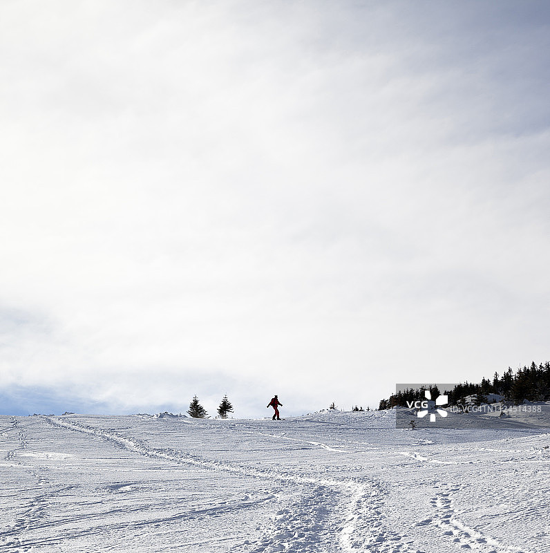 冬季雪坡上的滑雪者剪影图片素材