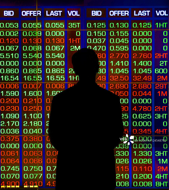 站在股价显示屏前的男人图片素材