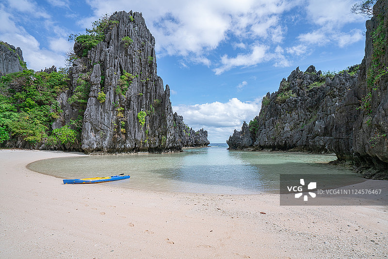年轻女人在美丽的热带泻湖中划独木舟图片素材