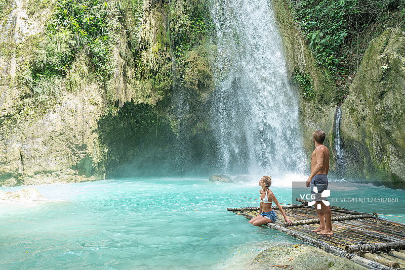 年轻夫妇欣赏热带瀑布美景图片素材