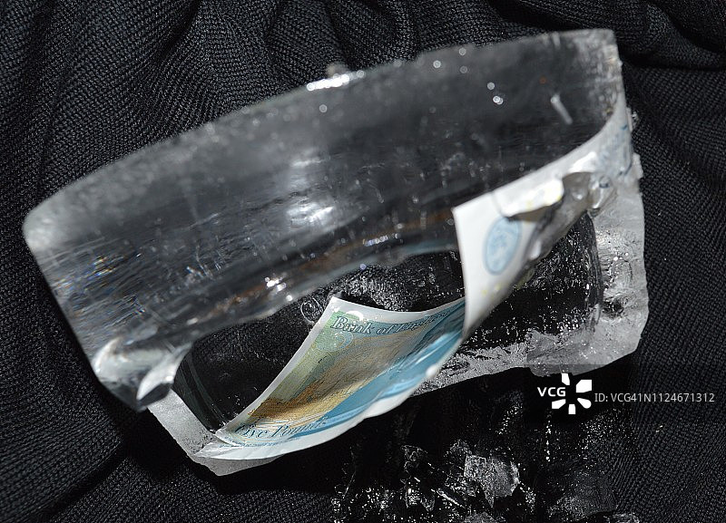 嵌入冰中的英国五英镑纸币图片素材