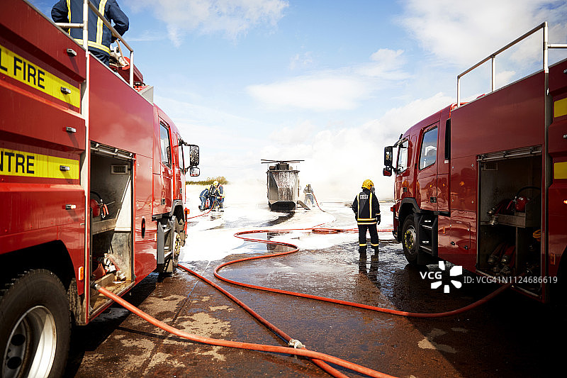 消防员训练：消防队在训练设施的模拟直升机上喷洒灭火泡沫图片素材