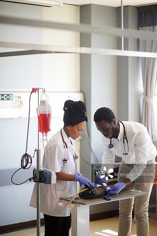 学生在静脉穿刺练习手臂上练习静脉注射（侧面）图片素材