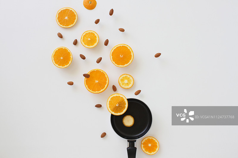 从煎锅中飞出的橙子切片和杏仁图片素材