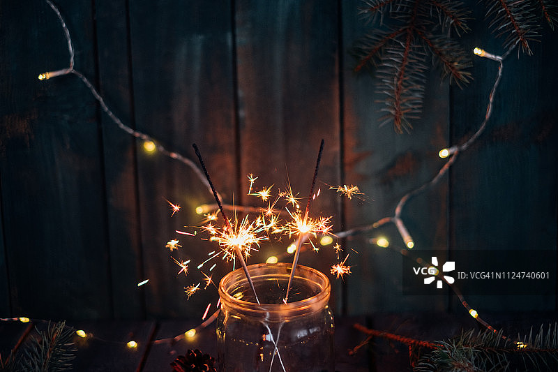装在玻璃罐中，带有节日灯的燃烧的闪光图片素材