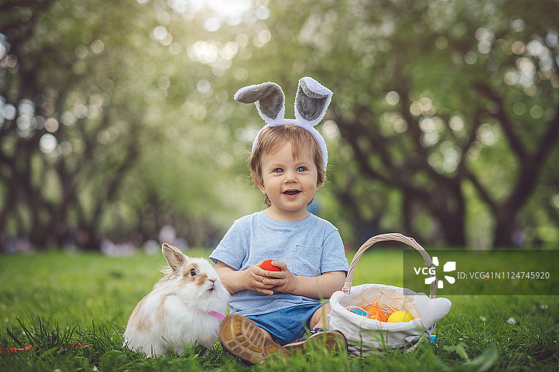 可爱的小男孩玩兔子和复活节彩蛋图片素材