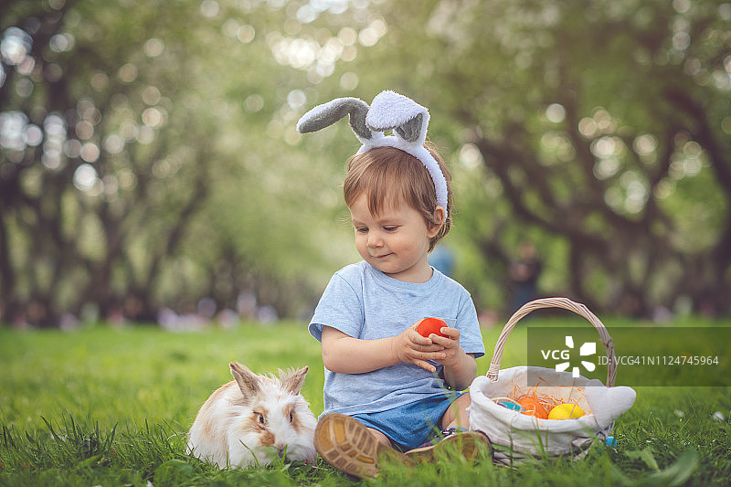 可爱的小男孩玩兔子和复活节彩蛋图片素材
