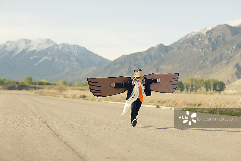 带着纸板翅膀的年轻商务男孩图片素材