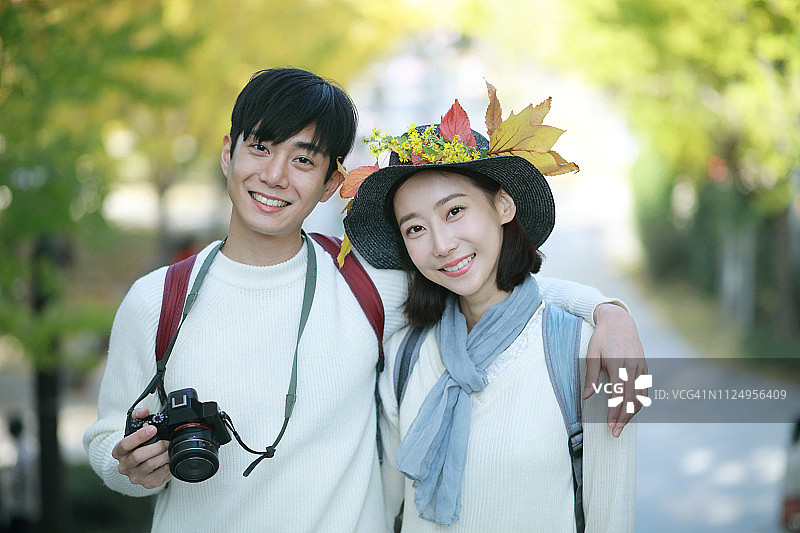 公园里用相机拍摄的年轻情侣肖像图片素材