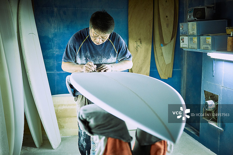 冲浪板工匠在工作室为传奇冲浪者签名图片素材