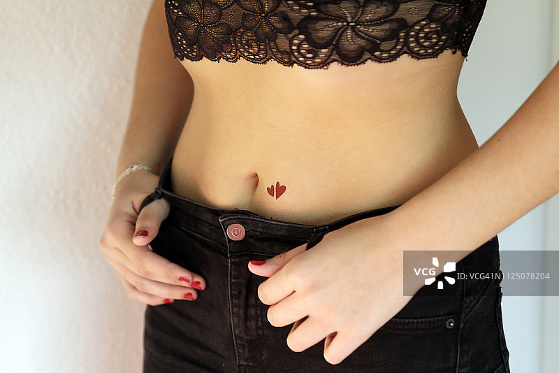 腹部有红色心形纹身的女人图片素材