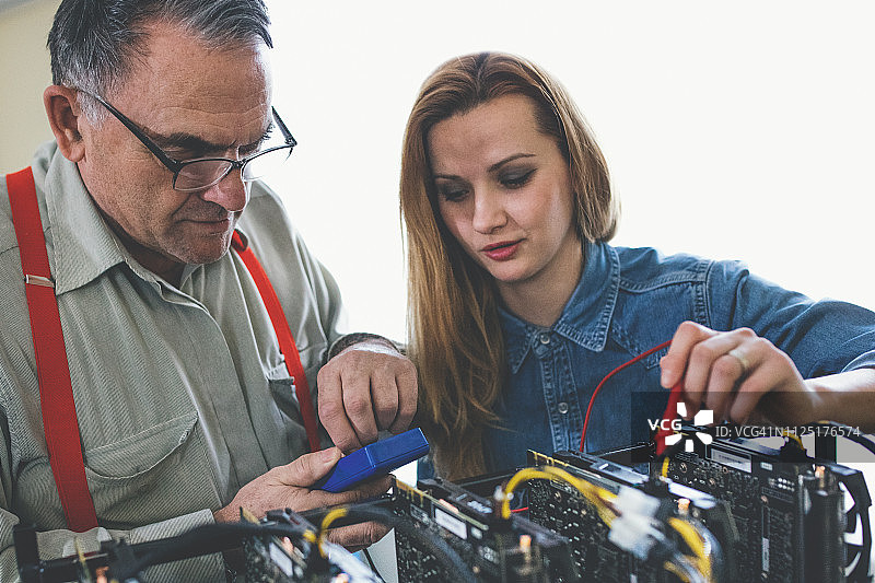 女人和她的父亲在进行加密货币挖掘工作图片素材