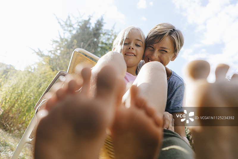 母女在花园里展示她们的脚图片素材