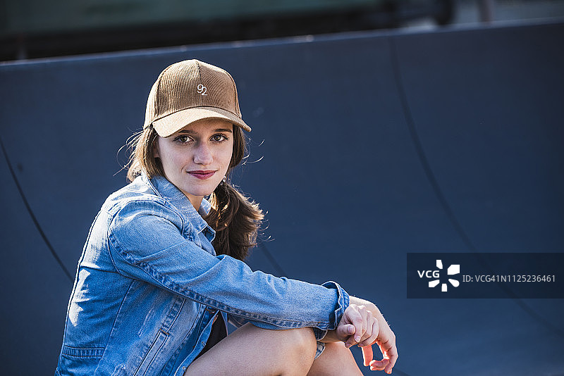 年轻女子坐在户外的微笑肖像图片素材