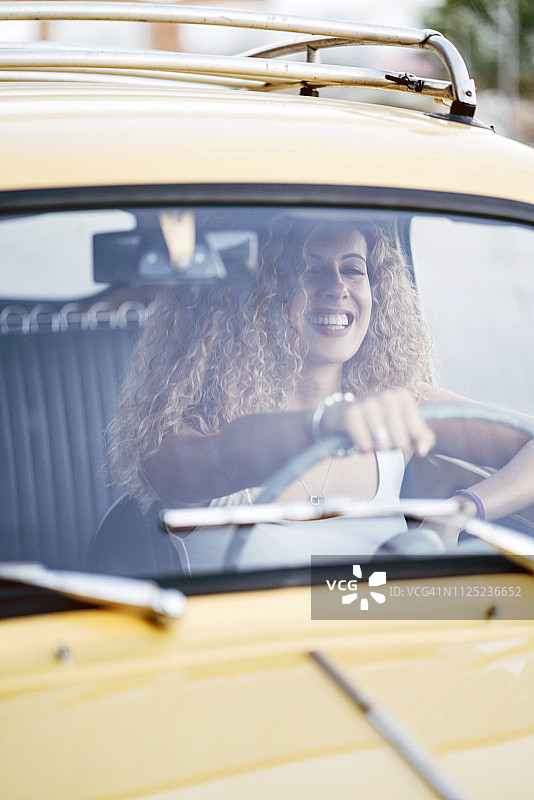 驾驶老爷车的笑金发女人图片素材