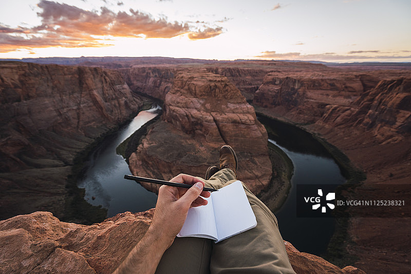 美国亚利桑那州科罗拉多河马蹄湾，年轻人和笔记本图片素材