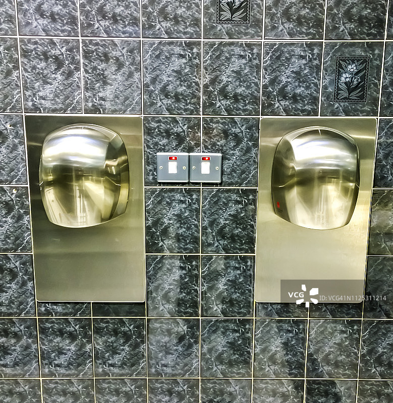 公共洗手间墙上的烘手机特写图片素材