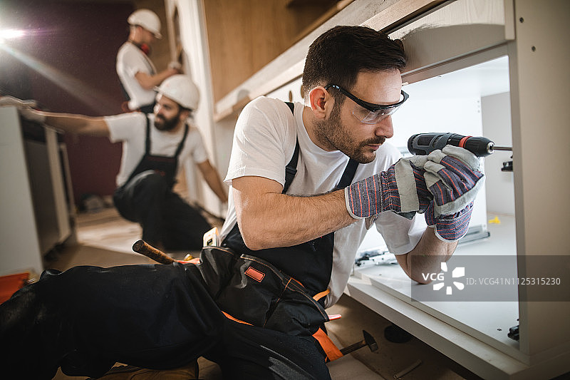 家装过程中使用钻头的建筑工人图片素材