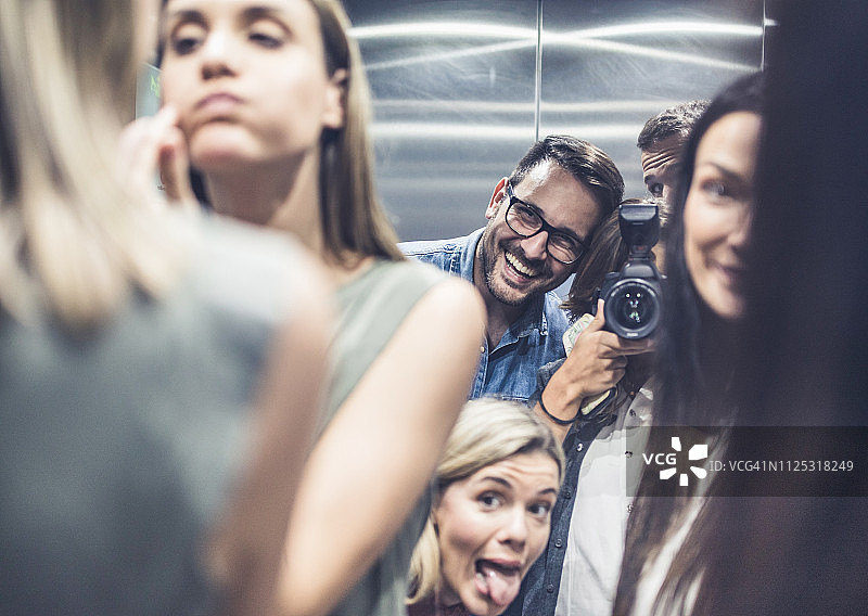 快乐的朋友们在电梯内自拍的倒影图片素材