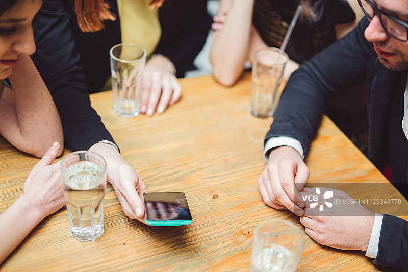 好朋友在咖啡馆里用手机回忆往事图片素材
