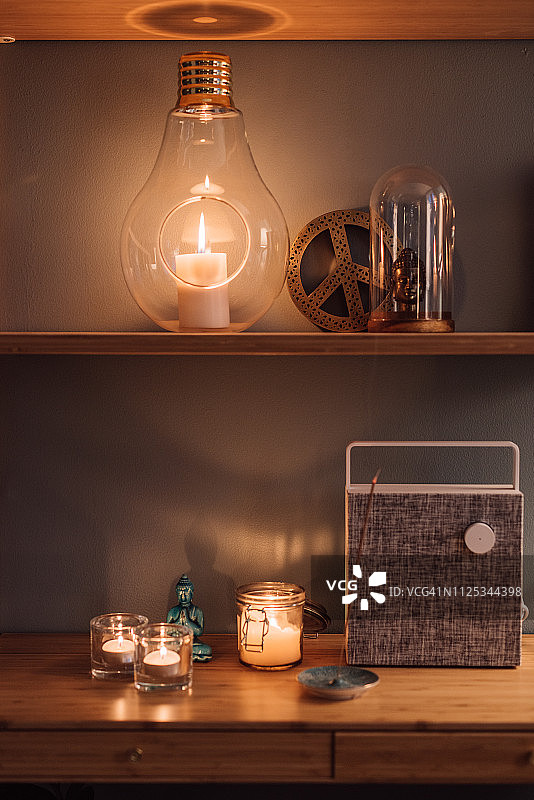 舒适的家居室内搁板，配有蜡烛和蓝牙无线音箱图片素材