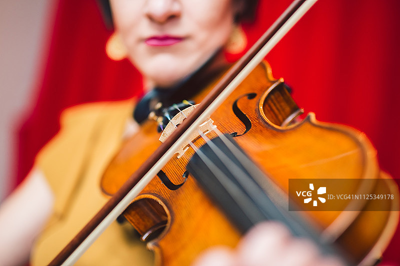 美丽的女人在舞台上演奏小提琴图片素材