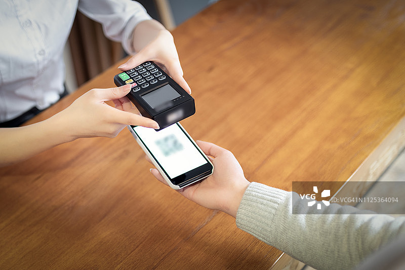 在咖啡馆用智能手机支付图片素材