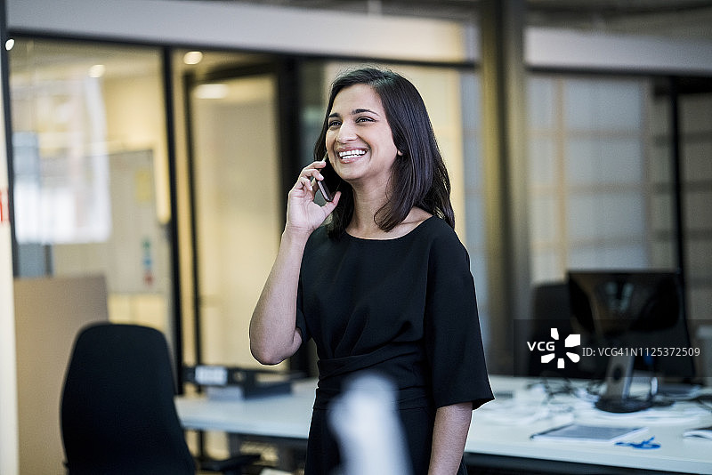快乐的女商人用智能手机交谈图片素材