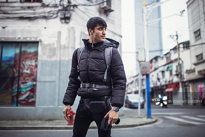 背着背包走在街上的年轻男人图片素材