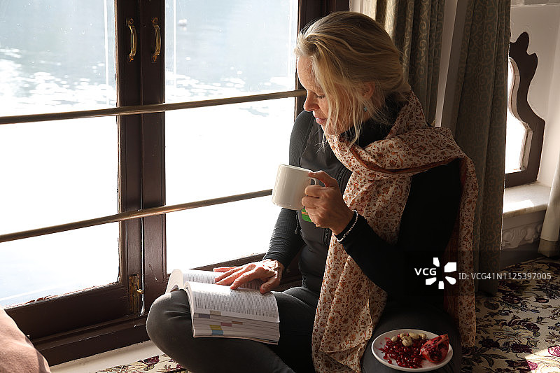 女人在窗边放松读书图片素材