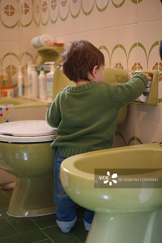 在厕所里玩耍的小男婴图片素材