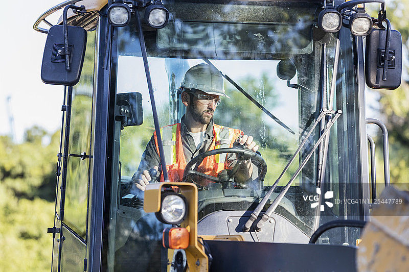 操作反铲挖掘机的建筑工人图片素材