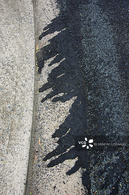 道路重铺后流入混凝土路缘的沥青图片素材