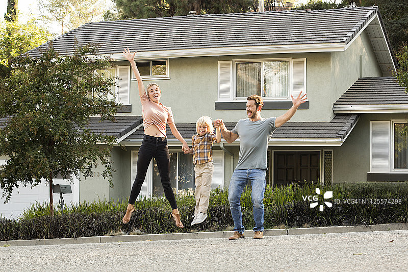 幸福家庭：儿子在自家门前跳跃图片素材