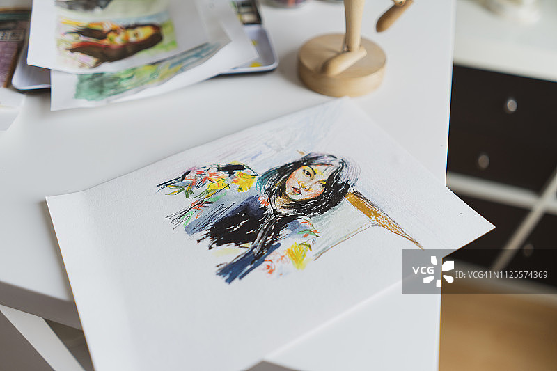 在工作室的办公桌上画着女性肖像图片素材