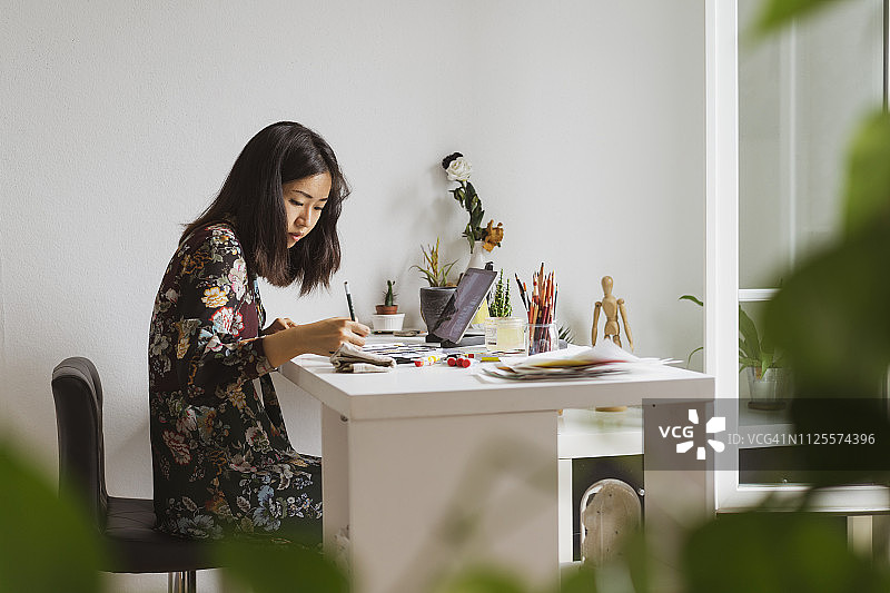 在工作室工作桌旁绘画的插画师图片素材