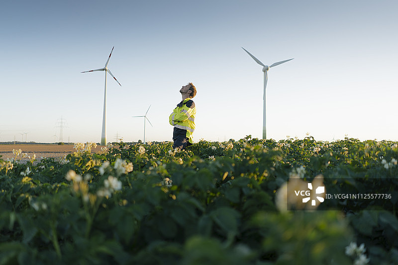 工程师站在风力发电场的田野里图片素材