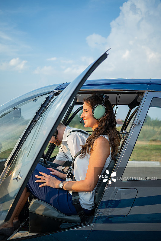 在直升机驾驶舱内开门微笑的女乘客图片素材