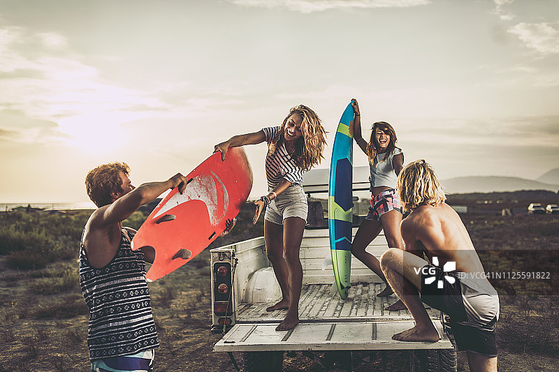 正在皮卡车上打包冲浪板的快乐情侣图片素材