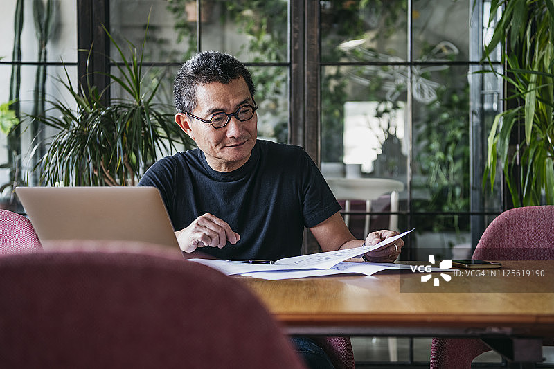 在家用笔记本电脑工作的中年中国男人图片素材