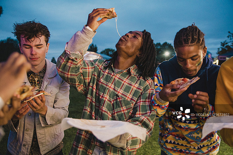 在节日上吃披萨的年轻人图片素材