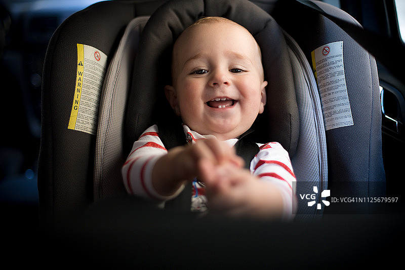 坐在汽车安全座椅上的快乐男婴图片素材
