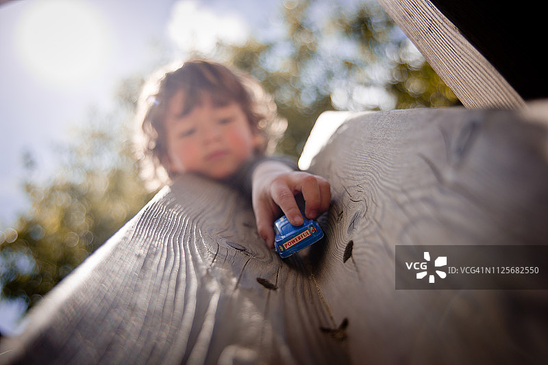 幼儿在坡道上扔汽车图片素材