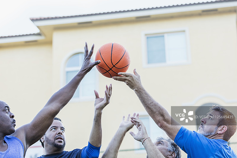 男人们打篮球，伸手争球图片素材