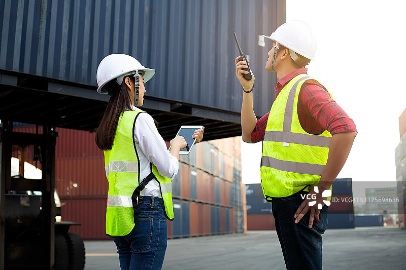 亚洲工头和秘书在船厂检查货运集装箱图片素材