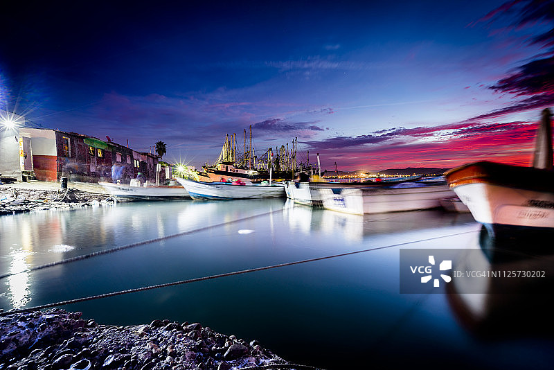 墨西哥锡那罗亚州马萨特兰太平洋沿岸城市渔船上的壮丽日出图片素材